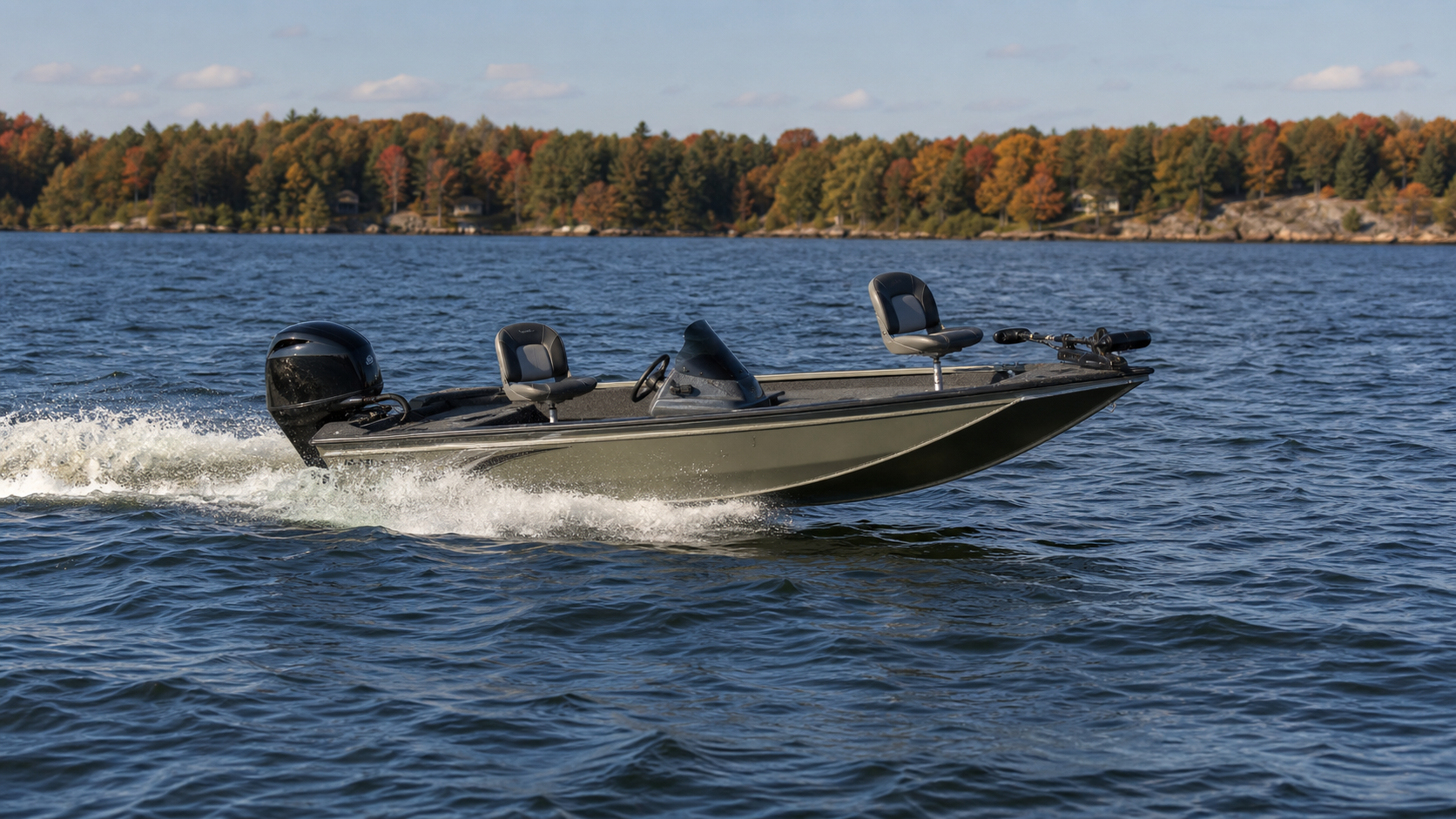 Small lake fishing boat moving across choppy water with wake and spray